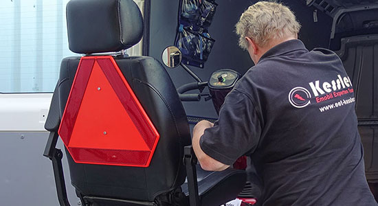 Mitarbeiter läd Kundenfahrzeug aus Transporter