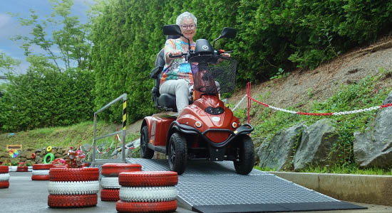 Ältere Dame fährt über dern Elektromobil-Testparcours